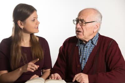 caregiver having a speech therapy to senior man