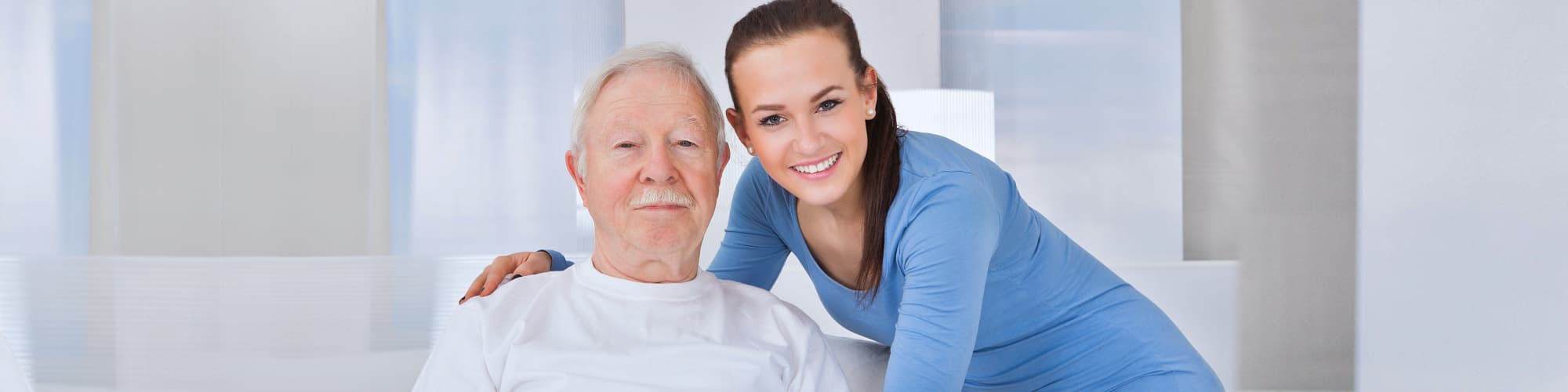 female caregiver and senior man smiling
